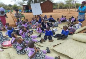 Children at AIC Maeni Satellite outdoor classroom