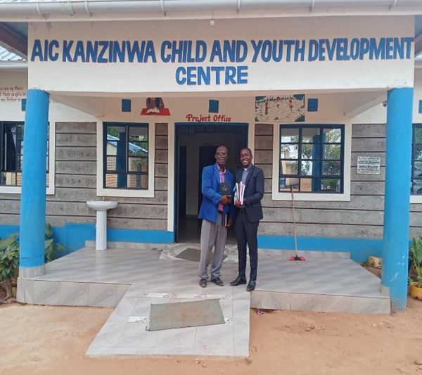 Trainers standing at AIC Kanzinwa CDC entrance